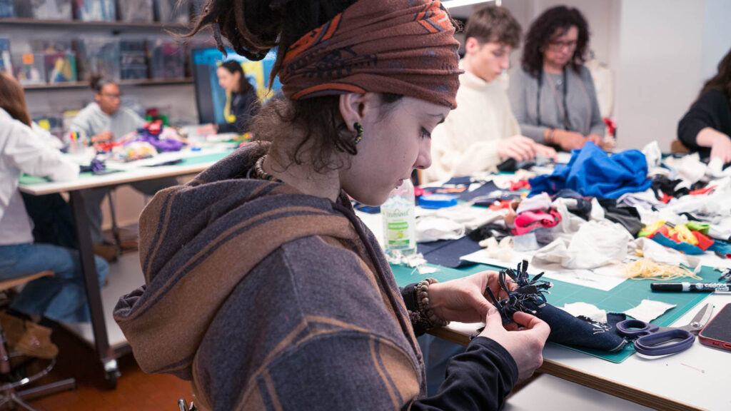 a group of people sitting around a table working on crafts