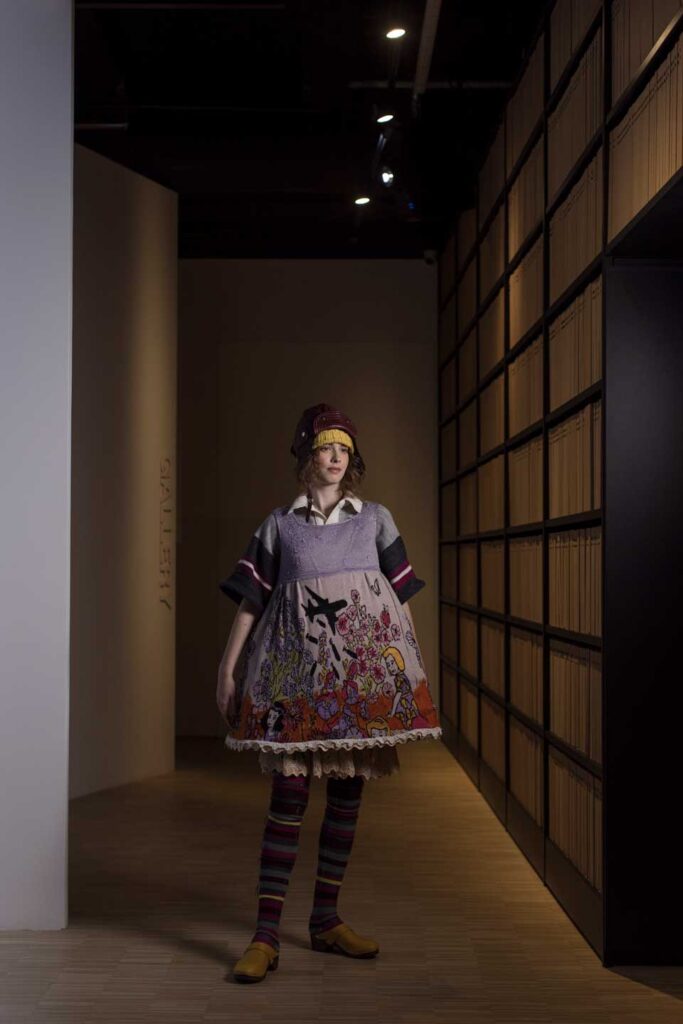 a woman standing in a room with a dress on