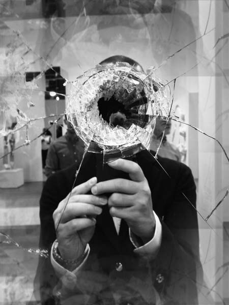 a man in a suit holding a broken glass object