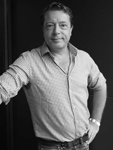 a black and white photo of a man leaning against a wall