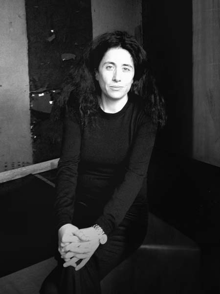 a black and white photo of a woman sitting on a bench