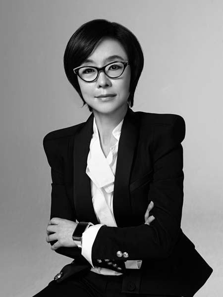 a woman in a suit and glasses posing for a picture