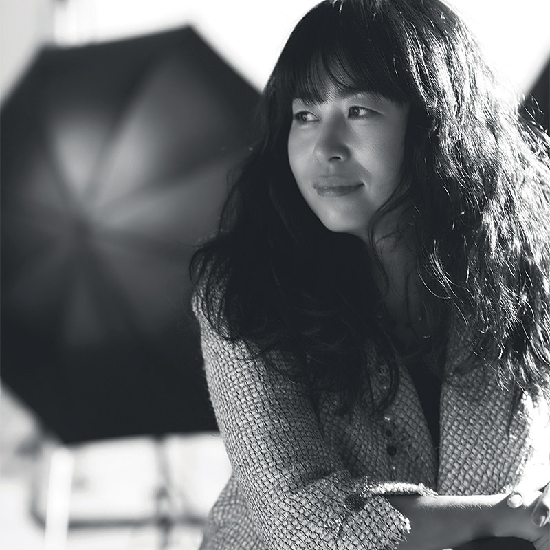 a black and white photo of a woman holding an umbrella