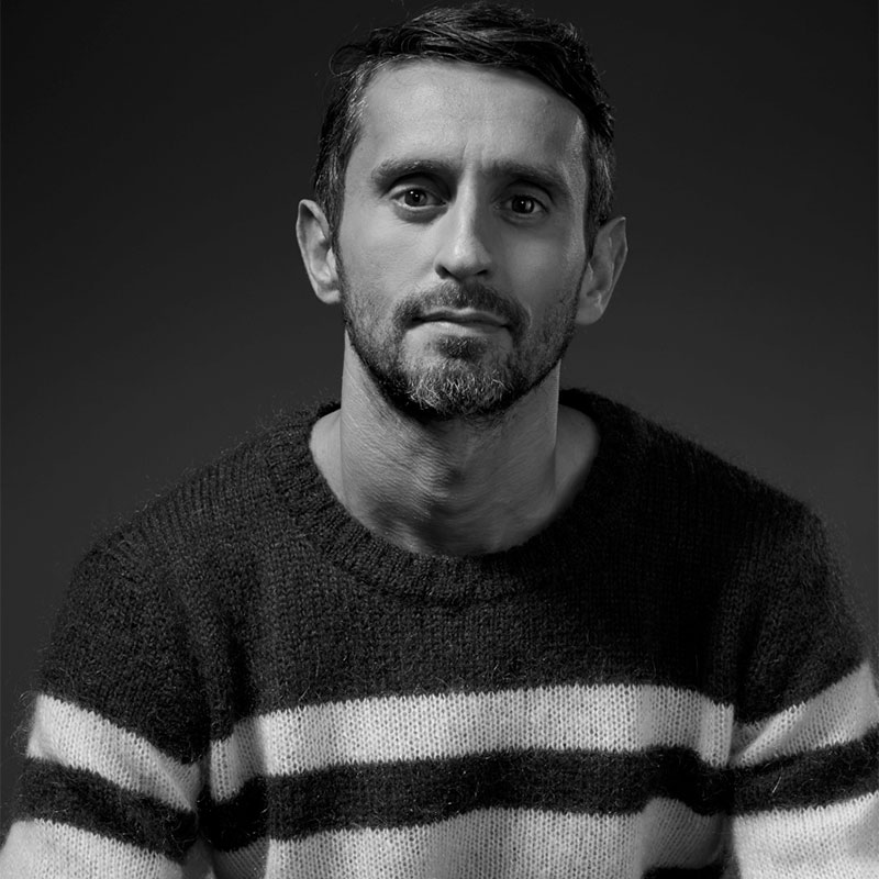 a man with a beard wearing a striped sweater