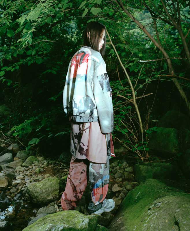 a person standing on a rock in the woods