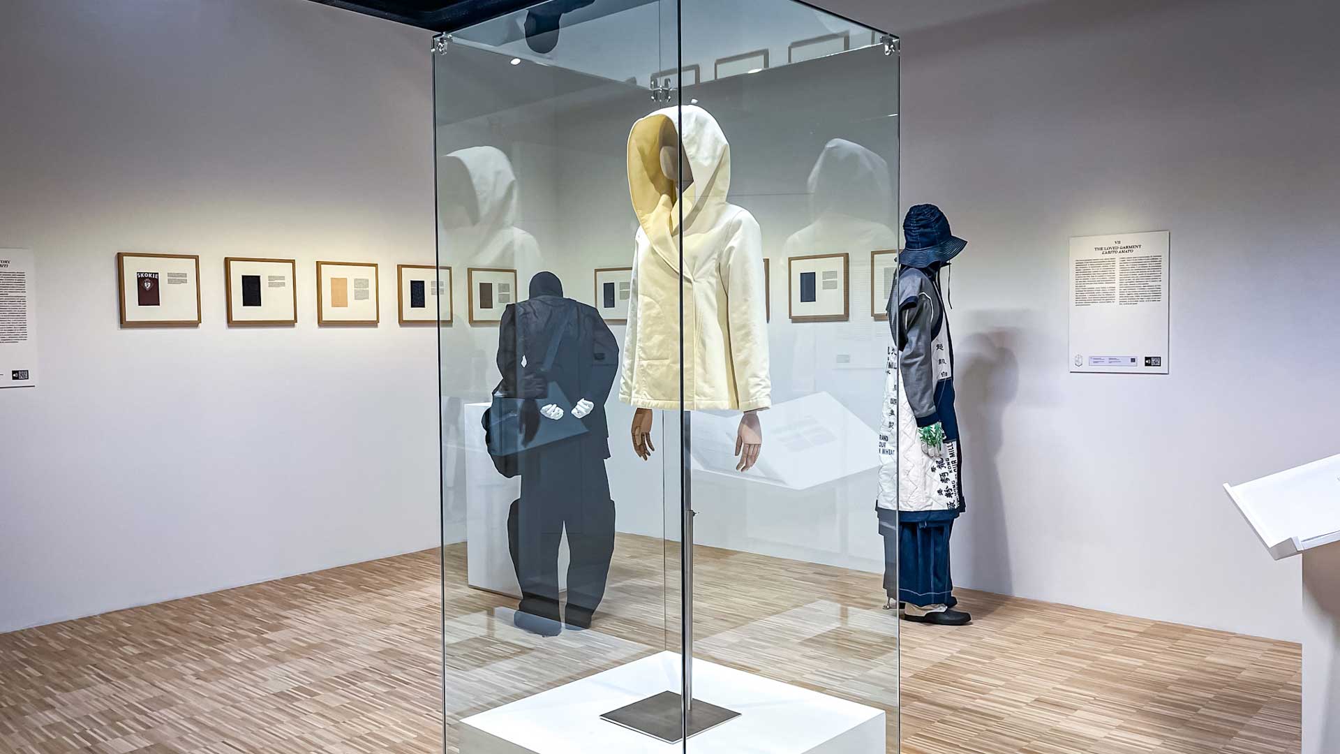 a glass case with mannequins inside of it