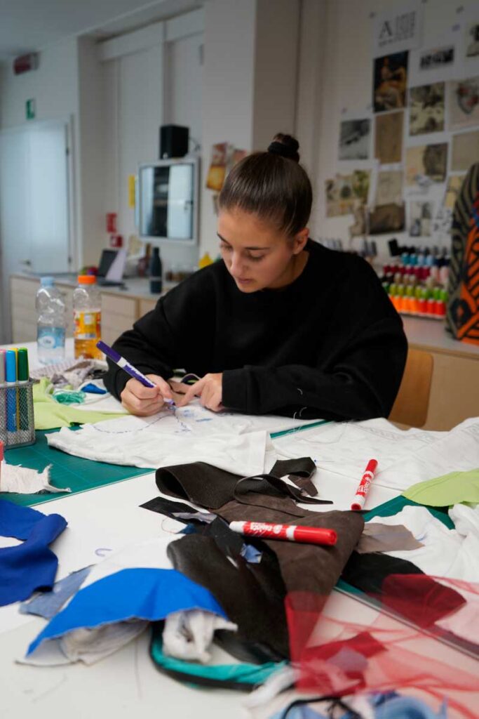 a woman sitting at a table working on a project