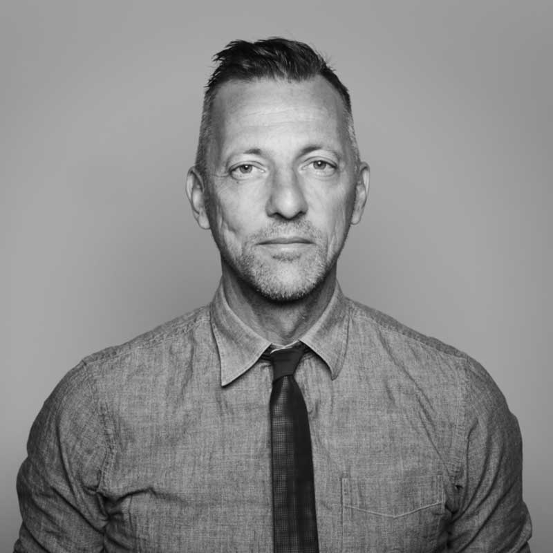 a black and white photo of a man in a shirt and tie