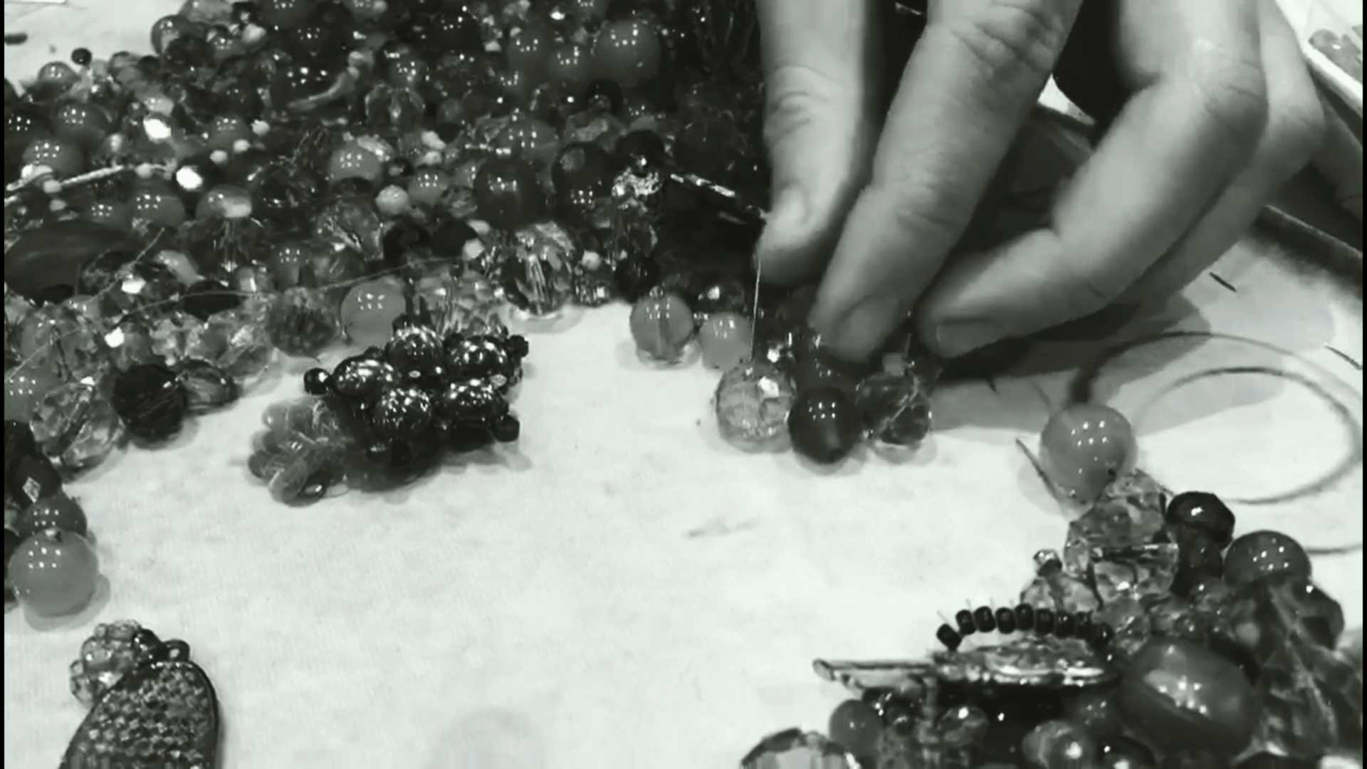 a black and white photo of a person making beads