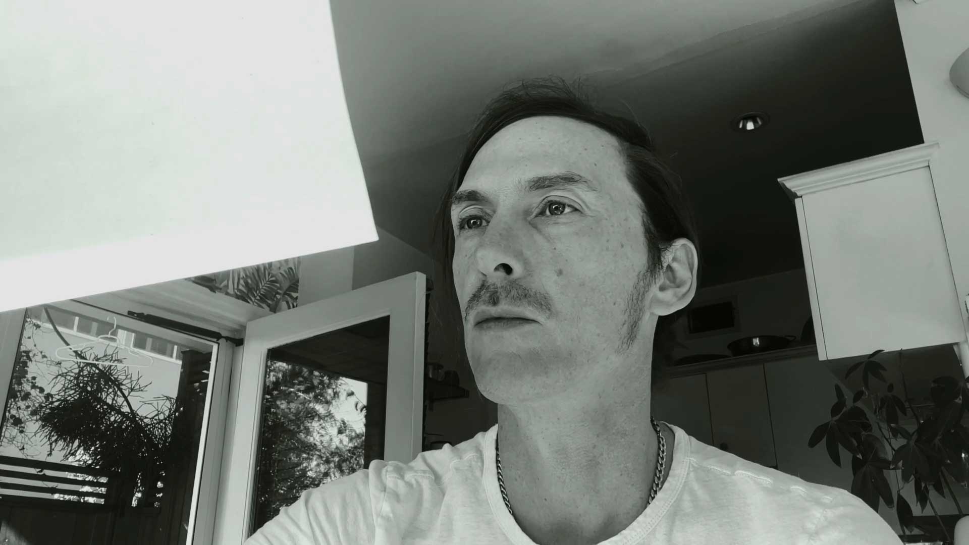 a black and white photo of a man in a kitchen